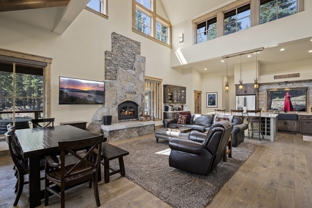 Main Floor living room with comfortable leather furniture and  large stone fireplace.
