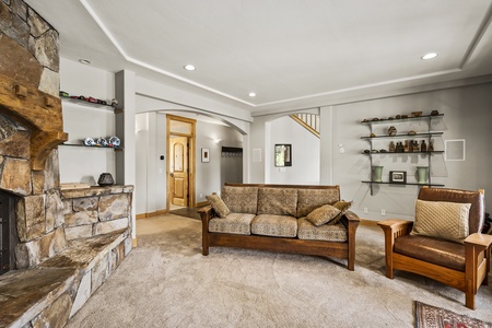 Lower Floor: plush leather furniture, a stone fireplace, and a flat-screen TV