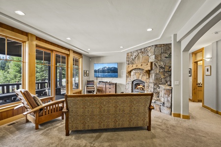 Lower Floor: plush leather furniture, a stone fireplace, and a flat-screen TV