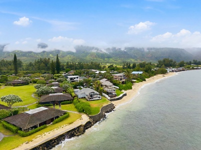 Beachfront property nestled along a tranquil bay, with misty mountain views and lush tropical surroundings framing this peaceful coastal community.