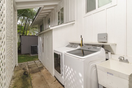 Your dedicated laundry area features a full-size washer and dryer in a private outdoor setting surrounded by tropical greenery.