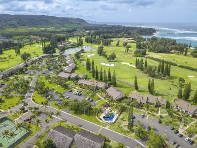 Aerial view of beachfront resort nestled between championship golf course and ocean coastline.