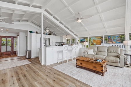 Relax in your airy, open-concept living space with soaring beamed ceilings, a fully equipped kitchen, and cozy coastal décor that invites you to unwind and feel at home.