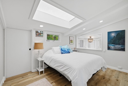 Drift into restful sleep beneath a skylight that fills your room with natural light. Crisp white linens and coastal artwork create a serene retreat after your day's adventures.