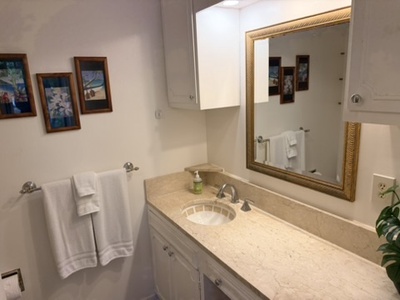 Your private bathroom features a spacious vanity with ample counter space, soft lighting, and crisp white towels waiting for you.