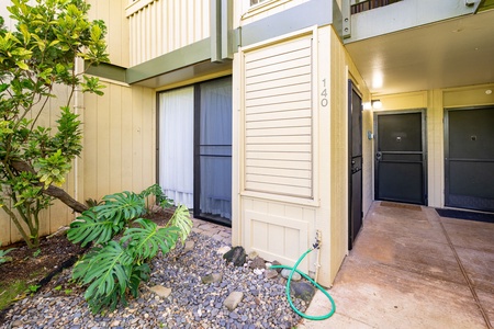Unit entrance with lush tropical landscaping and covered walkway leading to your private door.