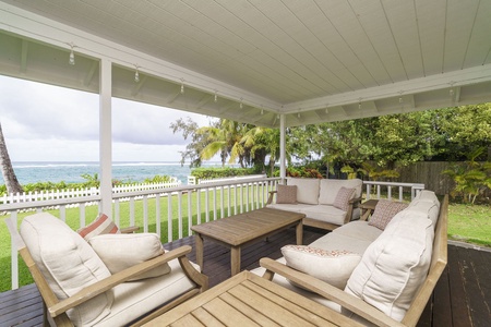 Unwind on your private covered patio with plush seating and stunning ocean views just steps from tropical gardens.