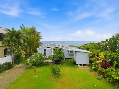 Coastal property featuring lush tropical landscaping and ocean views, nestled in a peaceful neighborhood near the water's edge.