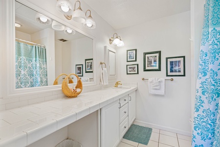 Step into your bright, elegant bathroom with dual vanities, beautiful artwork, and cheerful turquoise accents that create a spa-like retreat.