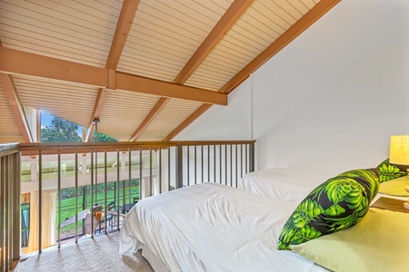 Wake up in your bright loft bedroom, where warm wood beams frame peaceful garden views through the window.