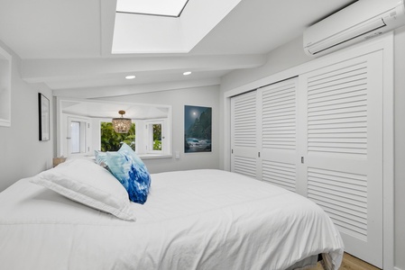 Drift off in your serene bedroom retreat, where soft natural light streams through the skylight and crisp white linens promise restful sleep in a peaceful, climate-controlled sanctuary.