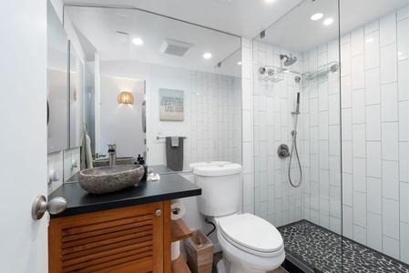 Step into your spa-like bathroom with a luxurious stone vessel sink, walk-in shower with sleek glass enclosure, and modern white subway tile that brings calm serenity to every refresh.