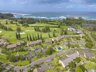 Stunning aerial view showcases the property's prime location next to championship golf course and beautiful coastline with ocean waves.