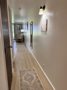 A welcoming hallway with warm lighting and polished floors leads you through the property, connecting all your spaces with clean lines and thoughtful décor touches.