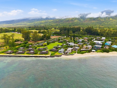 Beachfront property nestled along pristine shores with lush mountains rising in the background, surrounded by vibrant tropical landscapes and natural beauty.
