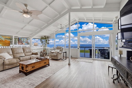 Imagine unwinding in this bright, airy living room where vaulted ceilings and expansive windows frame breathtaking ocean views. Your coastal retreat awaits with comfort and style.