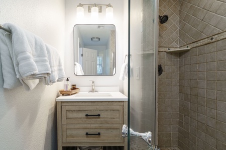 Your private spa-like bathroom features a rainfall shower, plush towels, and rustic vanity for your perfect morning routine.