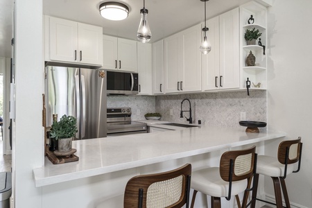 Cook your favorite meals in this bright, modern kitchen with sparkling countertops and stylish pendant lighting.