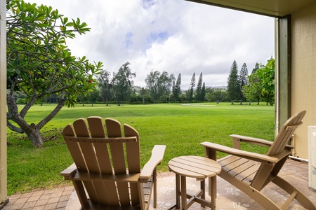 Step out onto your private patio and sink into an Adirondack chair overlooking lush, manicured greens framed by swaying tropical palms and towering pines—a serene escape for morning coffee or lazy afternoons.