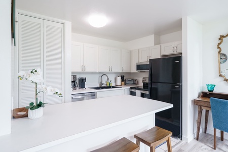 Step into your bright, modern kitchen with crisp white cabinetry and all the essentials for preparing your favorite meals. The spacious island invites you to gather, cook, and unwind.