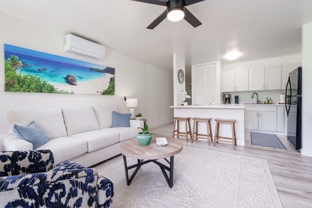 Step into your bright, open living space where coastal vibes meet modern comfort. Relax on the plush sofa, gather at the breakfast bar, and enjoy the seamless flow between living and cooking areas.
