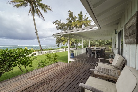 Your private deck overlooks lush gardens and sparkling ocean, where comfortable lounge chairs invite you to unwind with tropical breezes and stunning sea views.