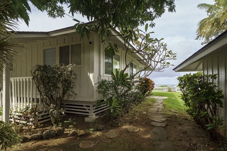 Charming tropical cottage nestled among lush greenery with stone pathways leading through your private garden sanctuary.