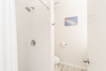 Step into your private bathroom with modern fixtures, clean white tile, and a refreshing shower—everything you need to unwind after a day of adventure.