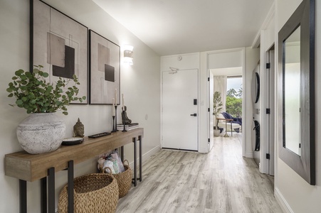 Step into your stylish entry hallway where modern coastal design meets comfort—complete with art, greenery, and glimpses of your oceanview sanctuary.
