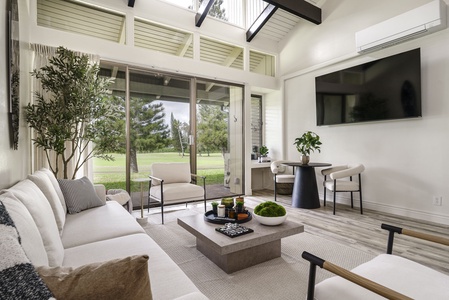 Unwind in your serene living space where floor-to-ceiling windows frame peaceful golf course views and modern comfort meets natural tranquility.