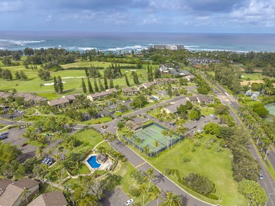 Aerial view of a resort community featuring golf course, tennis court, swimming pool, and oceanfront location with beach access.