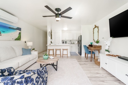 Step into your inviting open-concept living space with coastal vibes, comfortable seating, and a well-equipped kitchen ready for your stay.