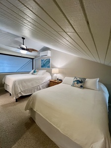 Sink into the comfort of two inviting beds beneath a charming vaulted ceiling. Your ceiling fan and air conditioning keep the space perfectly cool for restful nights after exploring the coast.