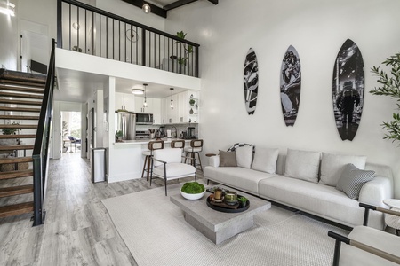 Relax in your stylish loft with soaring ceilings, modern kitchen, and cozy living space featuring surf-inspired art.