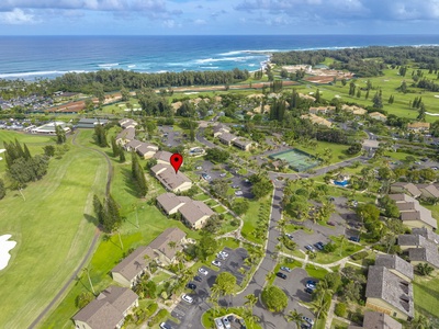 Aerial view of oceanfront resort property nestled between championship golf course and pristine Hawaiian coastline with convenient parking areas.