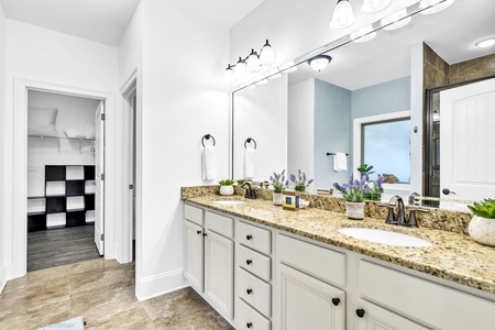 The master bath, with dual vanities, walk-in shower, soaking tub, and large walk-in closet.