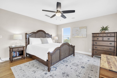 The 3rd floor master suite, featuring crisp linens, elegant furnishings, and a gentle ceiling fan for ultimate comfort.