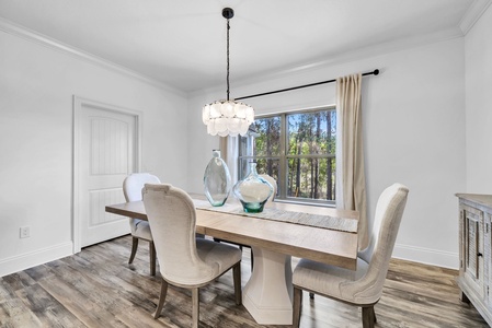 You'll love gathering around this elegant dining table, where natural light streams through large windows and stylish fixtures create the perfect ambiance for memorable meals.