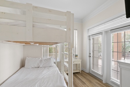 The ground floor bunk room features 2 full-size bunk beds and patio access!