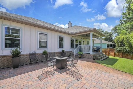 Step outside to your private patio with a fire pit and ample seating, where sunny skies and lush green surroundings invite you to relax and enjoy the fresh air.