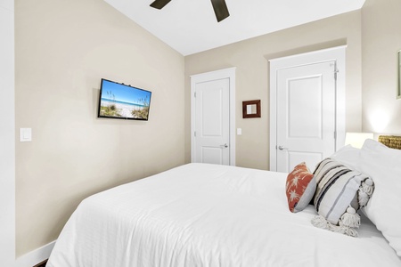 Sink into crisp white linens and unwind while watching your favorite shows on the wall-mounted TV in this peaceful bedroom retreat.