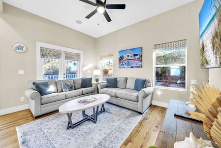 Sink into plush gray sofas in your bright living room, where coastal artwork and natural light create the perfect retreat.
