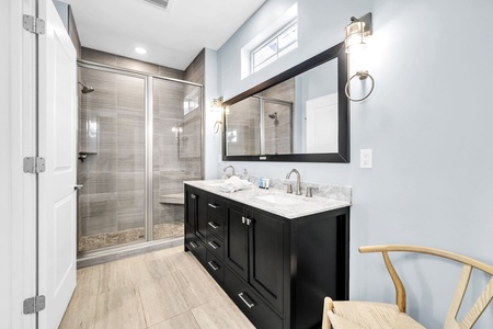 Your luxurious bathroom retreat features dual vanity sinks, marble countertops, and a spacious glass shower.