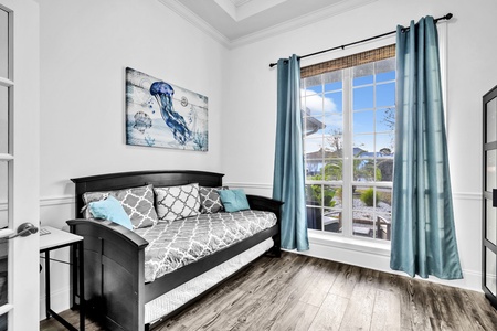 The daybed room with plentiful light, and entertainment center.