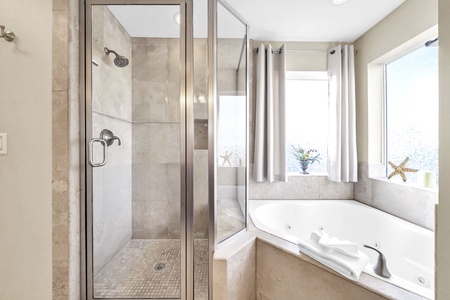 Unwind in your marble sanctuary with a glass shower and soaking tub, where natural light streams through picture windows.