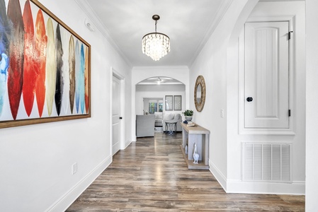 Step into this elegant hallway where contemporary artwork and a crystal chandelier create a sophisticated welcome to your stylish retreat.