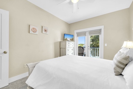 Your serene bedroom retreat offers crisp linens, a gentle ceiling fan, and coastal touches that invite restful sleep after a day of adventure.