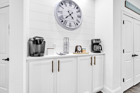 Start your morning right at your dedicated coffee station with a Keurig and full coffee maker, perfectly arranged on crisp white cabinetry.