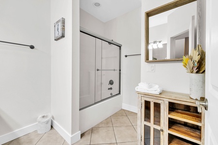 The 2nd floor guest bathroom, featuring a relaxing tub-shower combo and elegant rustic vanity with thoughtful touches.