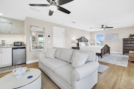 Relax in your spacious master suite with plush seating, ceiling fans, and a cozy bed—everything you need for the perfect getaway.